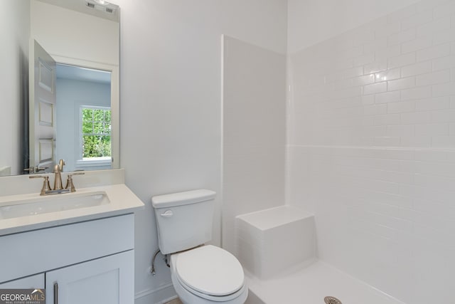 bathroom with a shower, toilet, vanity, and visible vents