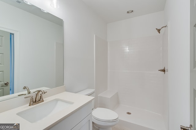 bathroom with vanity, a shower, and toilet