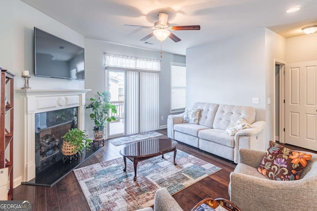 living room featuring a ceiling fan, wood finished floors, and a premium fireplace