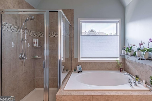 full bathroom featuring a shower stall, vaulted ceiling, and a garden tub