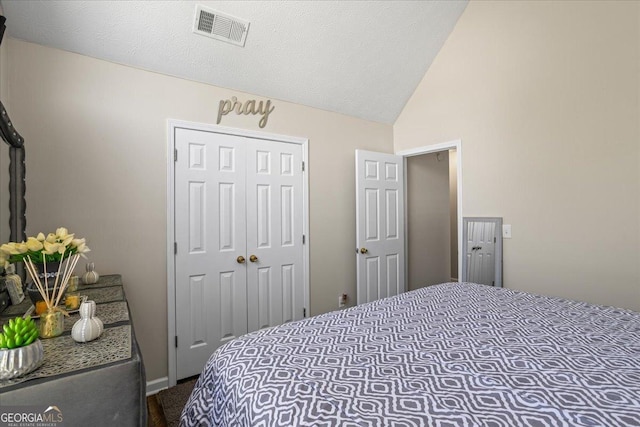 bedroom featuring vaulted ceiling, dark colored carpet, visible vents, and a closet