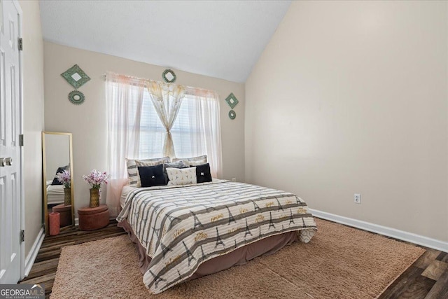 bedroom featuring vaulted ceiling, wood finished floors, and baseboards