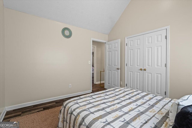 bedroom featuring a textured ceiling, vaulted ceiling, and a closet