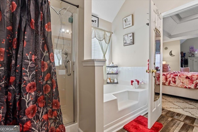 full bathroom featuring a shower stall, lofted ceiling, wood finished floors, connected bathroom, and a bath