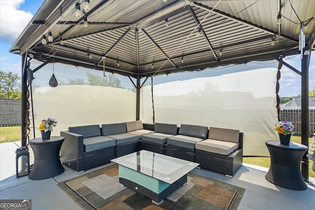 view of patio featuring fence, a gazebo, and an outdoor hangout area