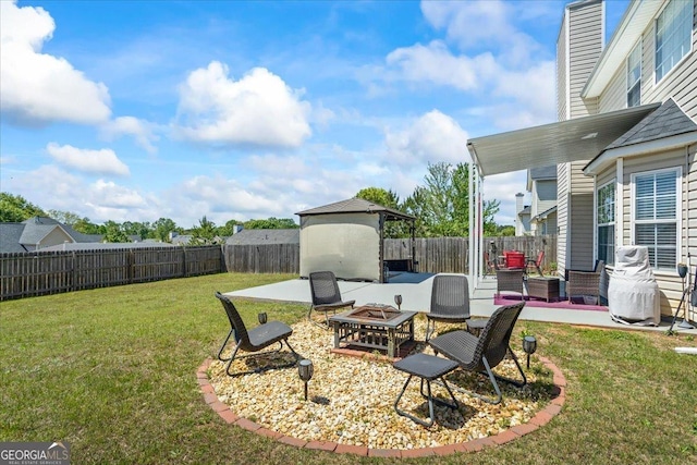 view of yard with a fenced backyard, a patio, and an outdoor fire pit
