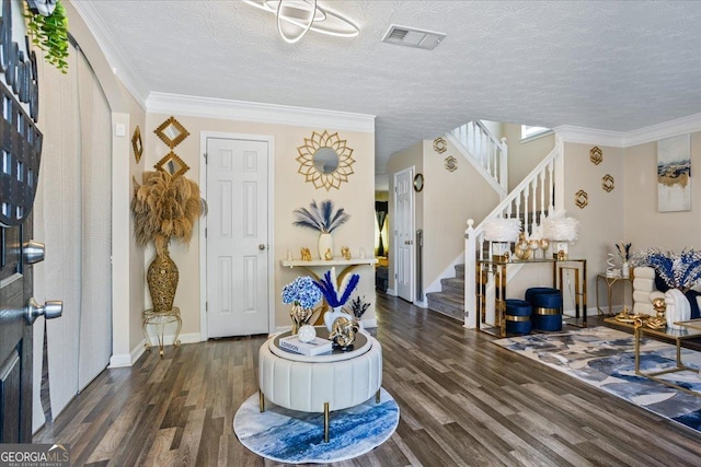 entrance foyer with stairway, wood finished floors, baseboards, ornamental molding, and visible vents