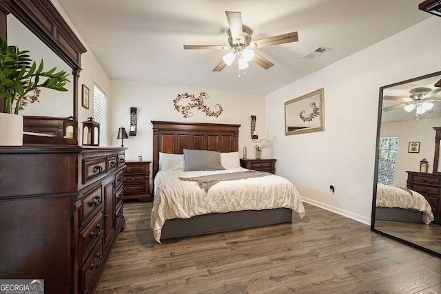 bedroom with baseboards, a ceiling fan, visible vents, and dark wood-type flooring