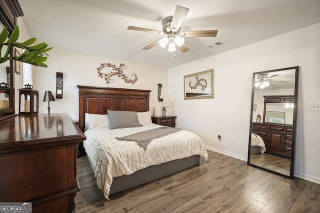 bedroom with visible vents, baseboards, and dark wood-type flooring