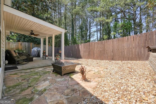 view of patio featuring a fenced backyard, a grill, an outdoor fire pit, and ceiling fan