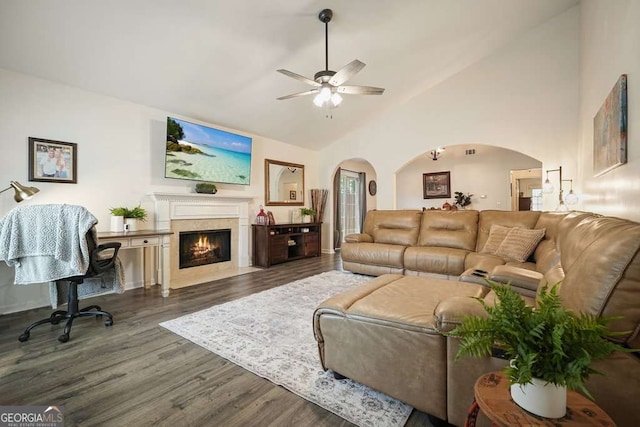 living room featuring a fireplace with flush hearth, ceiling fan, arched walkways, dark wood finished floors, and lofted ceiling