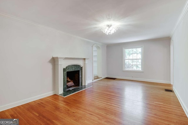 490 Mcwhorter Dr, Athens, GA 30606 - unfurnished living room with light wood finished floors, a high end fireplace, arched walkways, and crown molding