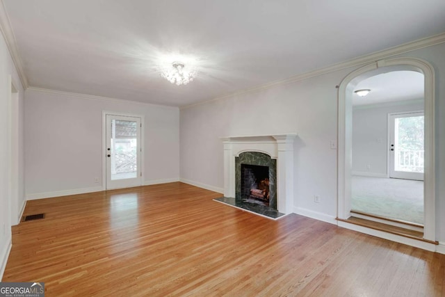 490 Mcwhorter Dr, Athens, GA 30606 - unfurnished living room featuring arched walkways, a premium fireplace, light wood-type flooring, and crown molding