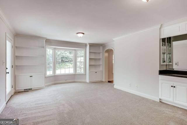 490 Mcwhorter Dr, Athens, GA 30606 - unfurnished room featuring crown molding, arched walkways, built in shelves, and light colored carpet