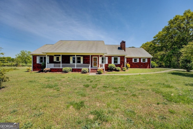 ranch-style home with a chimney, a front lawn, brick siding, and covered porch