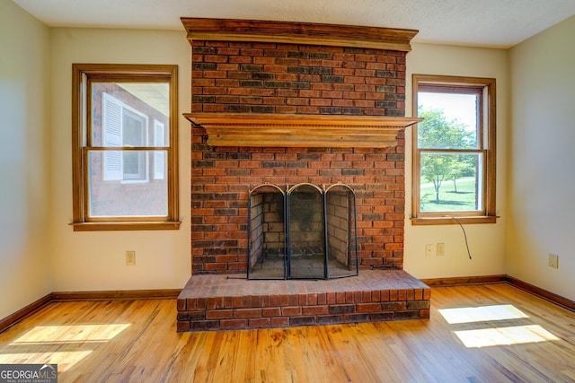 interior space featuring a fireplace, wood finished floors, and baseboards