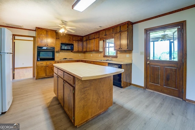 kitchen with tasteful backsplash, light wood-type flooring, visible vents, light countertops, and black appliances