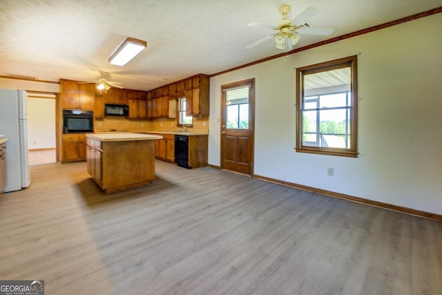 kitchen featuring light countertops, a ceiling fan, brown cabinetry, black appliances, and light wood-style flooring