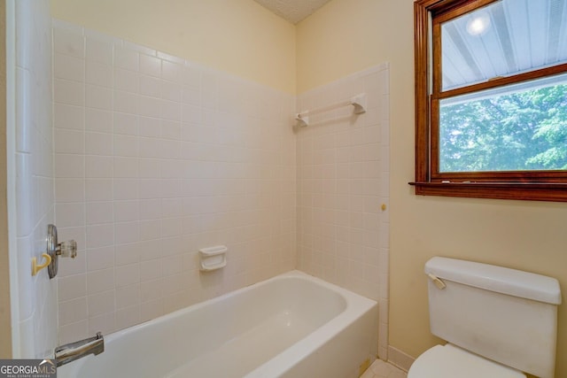 bathroom with shower / bathing tub combination, toilet, and baseboards
