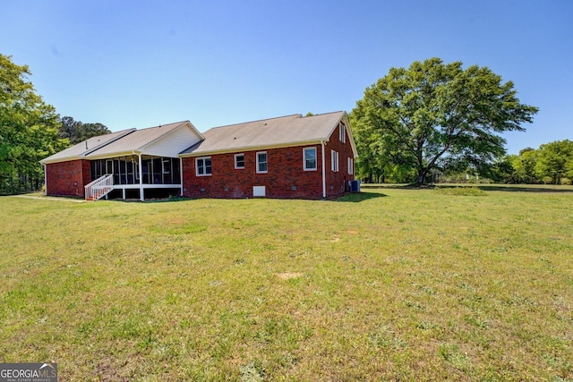 back of property with brick siding, a sunroom, a yard, and crawl space