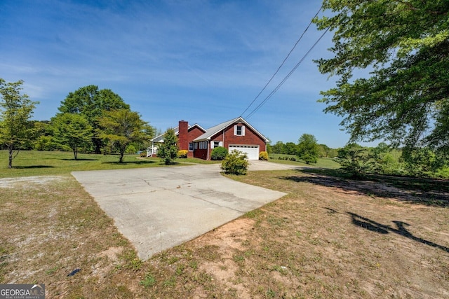 view of front of home with a garage, a front lawn, and concrete driveway