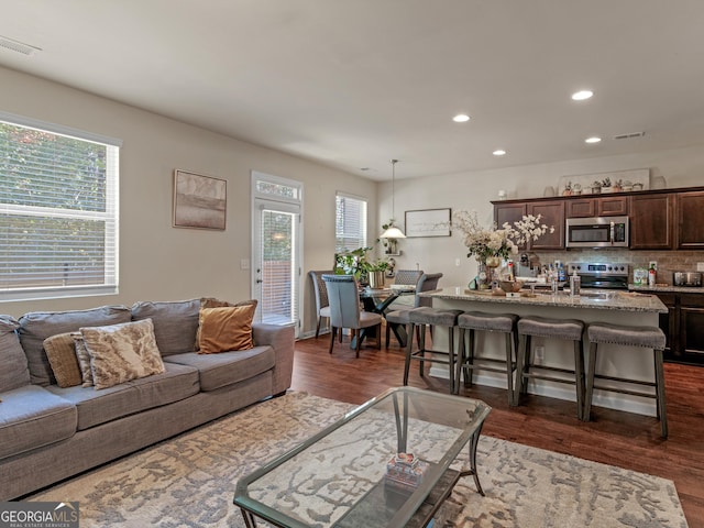 living area with recessed lighting and dark wood-type flooring