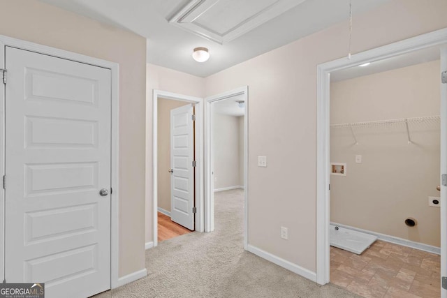 hall with baseboards and light colored carpet