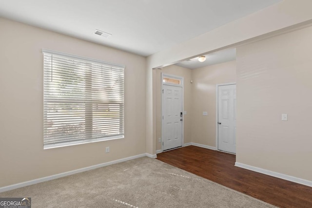 carpeted entrance foyer featuring healthy amount of natural light and baseboards
