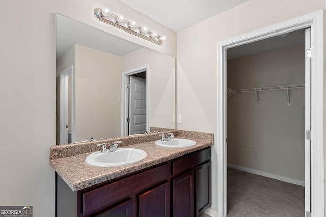 full bathroom with double vanity and a spacious closet