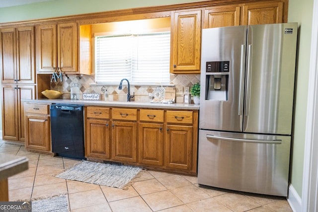 109 Trudie Ln, Macon, GA 31216 - kitchen featuring stainless steel fridge, black dishwasher, brown cabinetry, and decorative backsplash