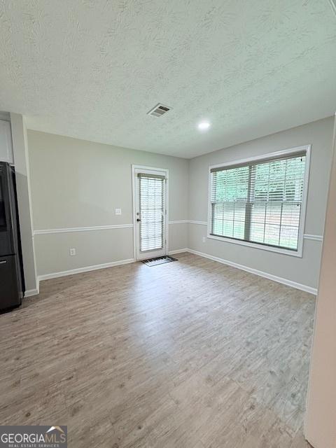 622 River Rock Cir, Jefferson, GA 30549 - unfurnished living room with a textured ceiling, wood finished floors, and baseboards