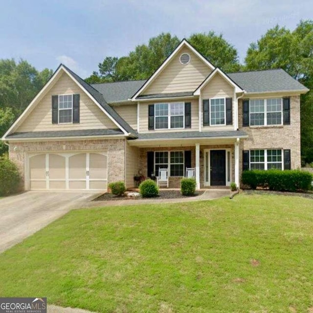 622 River Rock Cir, Jefferson, GA 30549 - view of front facade with concrete driveway, a porch, a front yard, and an attached garage