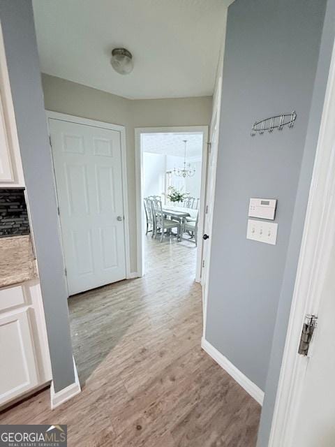 622 River Rock Cir, Jefferson, GA 30549 - hall featuring a chandelier, light wood-type flooring, and baseboards