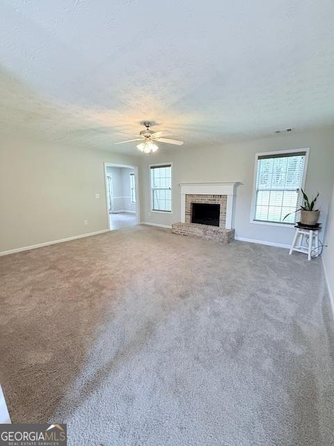 622 River Rock Cir, Jefferson, GA 30549 - unfurnished living room featuring baseboards, healthy amount of natural light, ceiling fan, and a textured ceiling