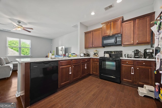 3203 Cyrus Point Ln, Kennesaw, GA 30152 - kitchen featuring black appliances, a peninsula, light countertops, open floor plan, and dark wood-style flooring