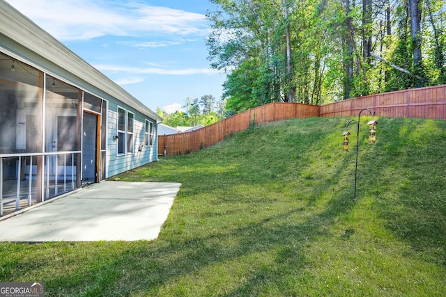 view of yard featuring a patio area, a fenced backyard, and a sunroom