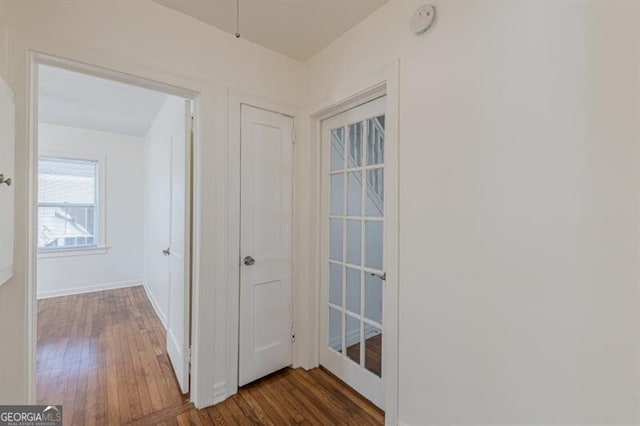 hallway with wood finished floors and baseboards