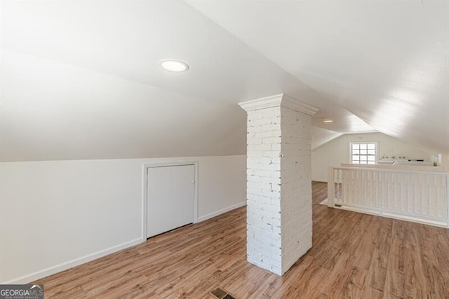 bonus room with lofted ceiling, light wood-style flooring, and baseboards