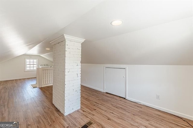 bonus room featuring lofted ceiling, wood finished floors, and baseboards