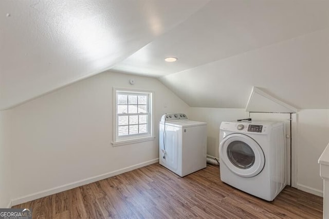 washroom featuring washer and dryer, wood finished floors, and baseboards