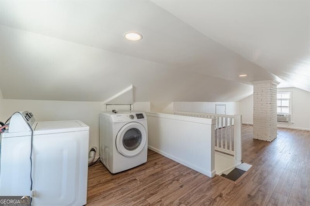 laundry area with washing machine and dryer, wood finished floors, and cooling unit
