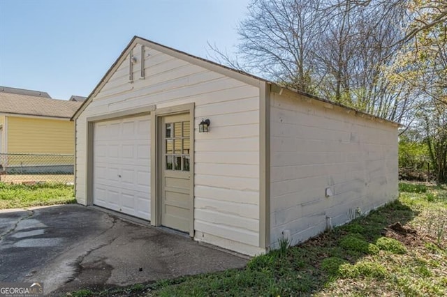 detached garage featuring fence