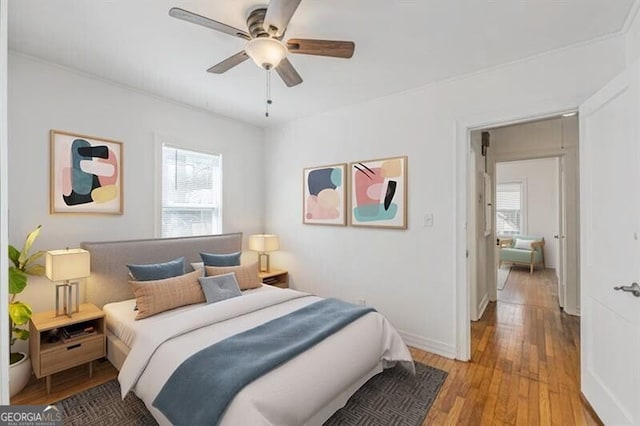bedroom featuring hardwood / wood-style flooring, baseboards, and a ceiling fan
