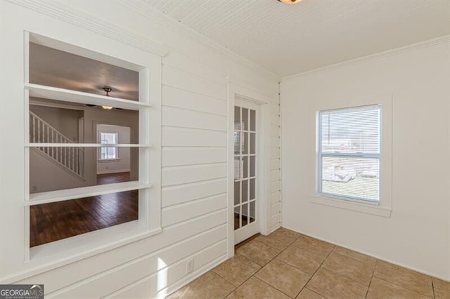 tiled spare room with crown molding