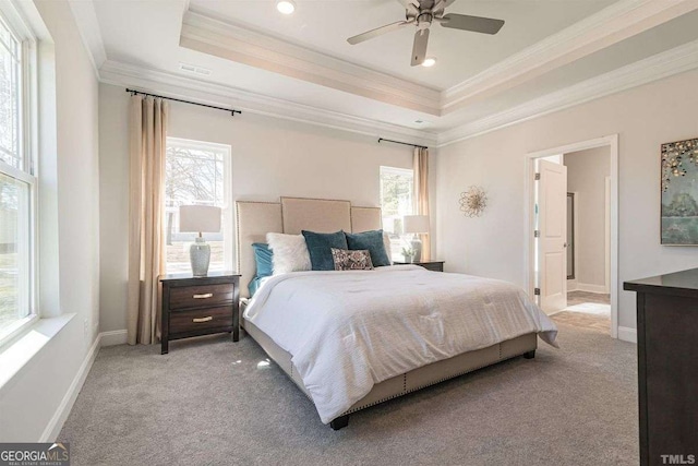 bedroom featuring a tray ceiling, light colored carpet, and ornamental molding