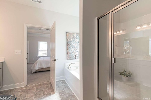ensuite bathroom with a bath, baseboards, vanity, and a stall shower