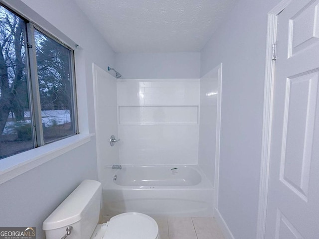 bathroom with tile patterned flooring, shower / bathing tub combination, a textured ceiling, and toilet