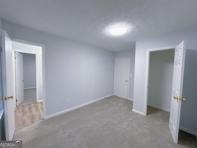 unfurnished bedroom with baseboards, carpet flooring, and a textured ceiling