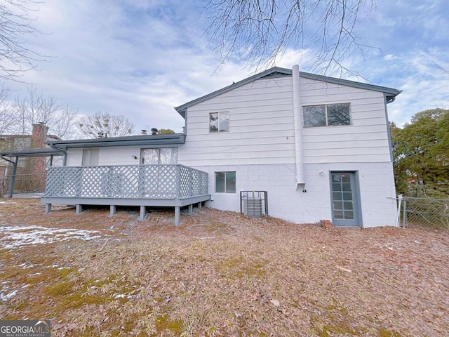 rear view of property featuring a wooden deck and fence