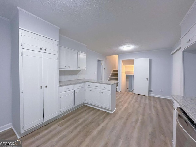 kitchen featuring stainless steel dishwasher, a textured ceiling, light wood-style floors, white cabinets, and a peninsula